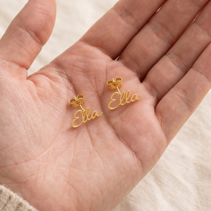 Paire de boucles d'oreilles prénom dans la main